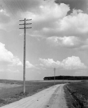 Roßtal. Telegrafenmasten an einer unbefestigten Landstraße