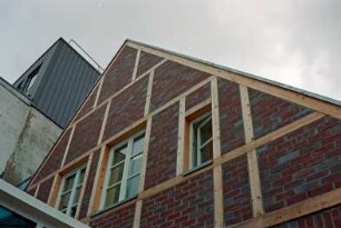 Mühlenstraße 21: giebelständiges Wohn- und Geschäftshaus: nach Sanierung: rückwärtige Giebelseite mit Fachwerk, Teilansicht: oben links Kaufhaus Nickel [angeschnitten]