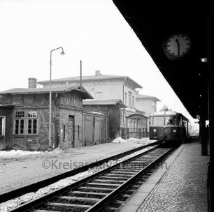 Bahnhof: Gleisanlage West: Bahnsteig, Uhr, Triebwagen: Bahnhofsinsel mit Bahnhofsgebäude, Nebengebäuden, Lichtmast