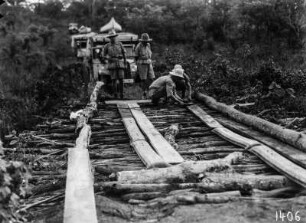 Vorbereitung zur Überfahrt : Expeditionsteilnehmer bereiten die Überfahrt einer Brücke mit den Fahrzeugen, welche im Hintergrund stehen, vor.