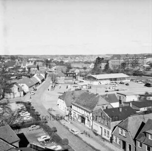Vogelperspektive: von Silo der Weizenmühle ("Gloria-Mühle") der Johannes Ströh Mühlenwerke am Pferdemarkt: Blick nach Nordosten: vorne Straße Pferdemarkt mit Kopfsteinpflaster, Häuser, Aral-Tankstelle, Parkplatz: Mitte Kreuzung, links Pferdemarkt, nach rechts quer Berliner Ring, nach hinten Segeberger Straße mit Kopfsteinpflaster: Bildmitte Shell-Tankstelle, rechts daneben Mercedes-Autowerkstatt, parkende Autos: hinten rechts St.-Josef-Stift