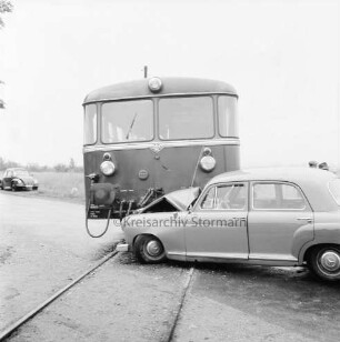 Bahnunfall: Eisenbahnstrecke der Elmshorn-Barmstedt-Oldesloe-Eisenbahn (EBOE): Bahnübergang Rümpeler Weg: Kollision eines Triebwagens mit einem Pkw: vorn links Gleis: rechts beschädigter Mercedes: dahinter Triebwagen: hinten links VW-Käfer: dahinter Wiese