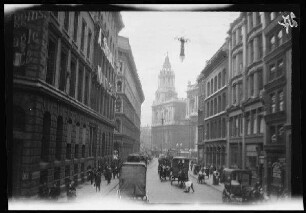 London (England): Pferdekutschen und Passanten in einer großen Straße mit einer Kirche im Hintergrund