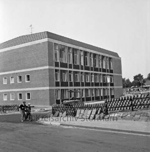 Rathaus und Bürgerhaus Glinde [später Marcellin-Verbe-Haus]: Neubau vor Fertigstellung: Blick vom Oher Weg: links zwei Jungen mit Fahrrad: dahinter Jägerzaun und Bagger