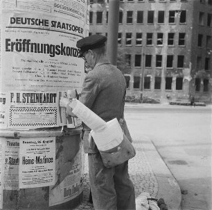 Berlin. Anbringen von Plakaten an einer Litfaßsäule - u. a. für das Eröffnungskonzert der Deutschen Staatsoper nach Kriegsende am 23.08.1945 im Admiralspalast