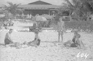 Touristen in Badekleidung am Strand