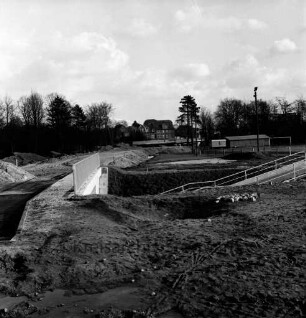Konrad-Adenauer-Ring: Baustelle der Fußgängerunterführung, rechts der Sportplatz am Exer, im Hintergrund die Travebrücke: Blick nach Westen
