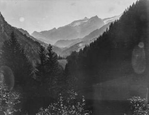 Im Gebirge : Blick über bewaldete Berghänge. Im Hintergrund ein Gebirge
