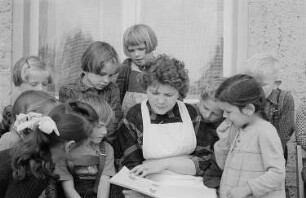 Eine Kindergärtnerin liest Kindern vor