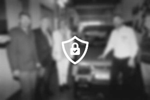 Autohaus von Hacht: 42. Beleuchtungsaktion: Werkstatt: Inhaber [Name maskiert] Karl-Heinz von Hacht mit Kfz-Innungsobermeister [Name maskiert] und dem Leiter der Polizeistation [Name maskiert] vor Pkw: 30. September 1998