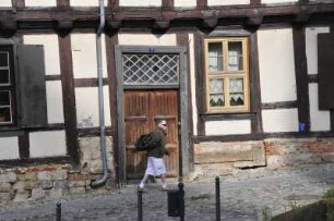 Quedlinburg - Desolates Fachwerkhaus : Passantin vor einem desolaten Fachwerkhaus am Schlossberg. Aufgenommen am 20. Juli 2012 in Quedlinburg