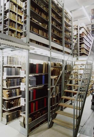 Sächsische Landesbibliothek - Staats- und Universitätsbibliothek Dresden. Zentralbibliothek (ehem. Landesbibliothek). Erdgeschoss (Flachbau). Abteilung Benutzung, Magazin mit Treppe zum aufgeständerten Zwischenboden : Dresden-Neustadt, Marienallee 12. Sächsische Landesbibliothek - Staats- und Universitätsbibliothek Dresden. Zentralbibliothek (ehem. Landesbibliothek). Erdgeschoss (Flachbau). Abteilung Benutzung, Magazin mit Treppe zum aufgeständerten Zwischenboden