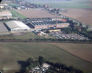 British American Tobacco (BAT): Luftbild des Gewerbegebietes am Beimoorweg: in der Bildmitte Bahnstrecke Hamburg-Lübeck, unten mittig Schrottplatz