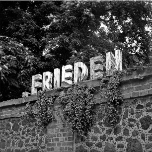 Friedhofsmauer mit Aufschrift "Frieden" aus Holzbuchstaben