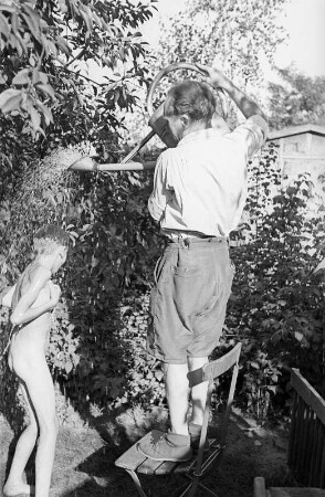 Porträt von Walter Dehmel mit Familie im Garten : Walter Dehmel duscht seinen Enkelsohn mit der Gießkanne
