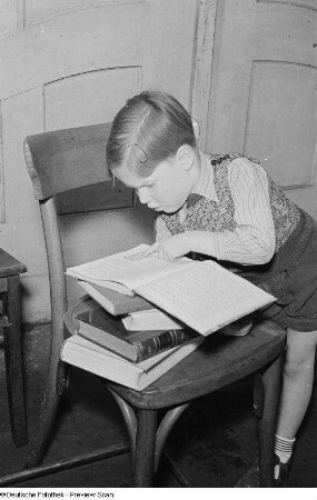Porträt eines kleinen Jungen beim Lesen eines Buchs
