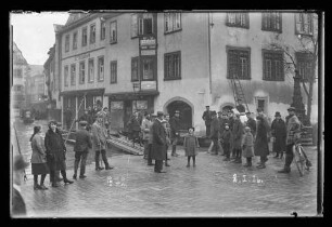 Hochwasser in der Brückengasse vor der Chorstift-Drogerie und Geschäft J.F. Schubert, sichtbar auch der Brunnen in der Lindenstraße, mit Personen davor, darauf Nr. 72