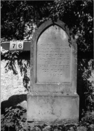 Grabstein 76 (Index: 100086542) Material: Sandstein Zustand: leicht verwittert Maße HxBxT: 152x54x16 cm Beschreibung: Stele, getreppter Sockel, Spitzbogenabschluß: Grabstein 76