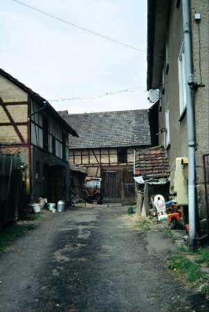 Blick in einen Dreiseithof; hinten Scheune, rechts Wohnhaus
