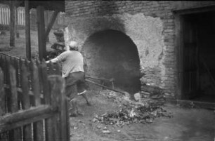 Brotbacken : Frau an einem Brotbackofen