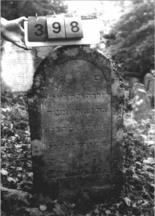 Grabstein 398 (Index: 99799634) Material: Sandstein Zustand: verwittert Maße HxBxT: 95x46x7 cm Beschreibung: Stele, eingezogener Rundbogenabschluß, Schriftfeld eingetieft Besonderheit: Kindergrab: Grabstein 398