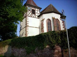 Ansicht von Ostsüdosten mit Kirche (im Kern Frühromanisch-Chor Spätgotisch neu erbaut) über Kirchhofmauer (Wehrgang mit Steinbrüstung im 18 Jh abgetragen
