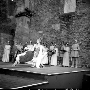 Aufführung eines Theaterstückes auf einer Freilichtbühne (in einer Ruine?)