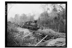 Bauzug mit Arbeitern : Nordthailand. Streckenbau für die Eisenbahn durch den Dschungel. Bauzug mit Arbeitern an provisorischer Brücke, 1908/1909