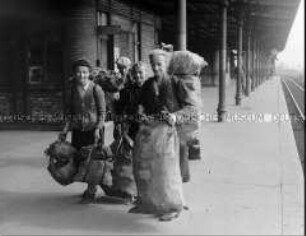 Frauen mit Brennholz auf einem S-Bahnhof