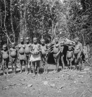 Gruppenportrait : Portrait von Frauen und Kindern vor einer Hütte