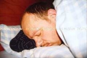 Schlafender Mann im Bett (Sonderthema: Familienbilder)