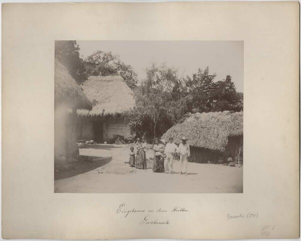 "Natives in front of their huts"