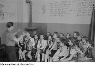 Chorleiter mit singenden Pionieren