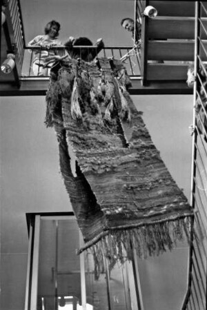Rathaus: Ausstellungsaufbau im Treppenhaus mit Objekten von Edith Schaar: Webobjekt der Künstlerin wird aufgehangen