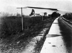 Sacramento River Deich : Straße in einer Landschaft mit Haus im Hintergrund. Straße verläuft vermutlich auf einem Deich des Sacramento Flusses
