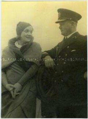 Marlene Dietrich und Kapitän Leopold Ziegenbein auf der Kommandobrücke des Hochseepassagierdampfers "Bremen", an den Maschinentelegrafen gelehnt
