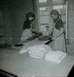 Arbeitsmaiden beim Bügeln der Wäsche in einem Lager des Reichsarbeitsdienstes in Mecklenburg