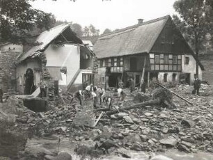 Unwetterkatastrophe im Osterzgebirge am 8./9. Juli 1927. Zerstörte Häusergruppe in Schönwald (heute Petrovice-Krásny Les). Ansicht mit beginnenden Aufräumarbeiten