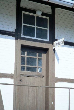 Eingangstür und Fenster, darüber Schild "Güterkasse"
