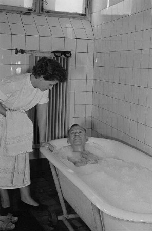 Portrait eines Patienten in der Badewanne und einer Pflegekraft in der Betriebspoliklinik der Transmasch Leipzig