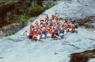 Gruppe von Schülerinnen auf einem Felsen sitzend