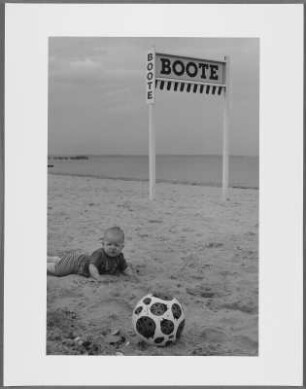 Im Sand liegendes Baby mit einem Ball, Timmendorfer Strand