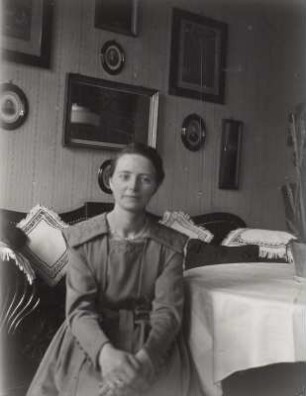 Stendal. Lene Blume, Ehefrau des Fotografen, im Wohnzimmer auf einem Sofa sitzend, Juni 1918
