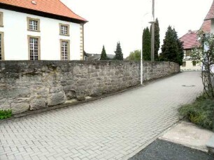 Evangelische Pfarrkirche - Ansicht von Nordosten mit Langhaus über Kirchhofmauer (Wehrgang mit Brüstung und Schießscharten abgetragen) in übersichtlichem Verlauf nach Westen