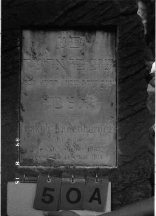 Grabstein 50 (Index: 100105505) Material: Muschelkalk, weiße Marmorplatte Zustand: leicht verwittert Maße HxBxT: 108x47x15 cm Beschreibung: Stele, rustica, rechteckige Schriftplatte: Grabstein 50A