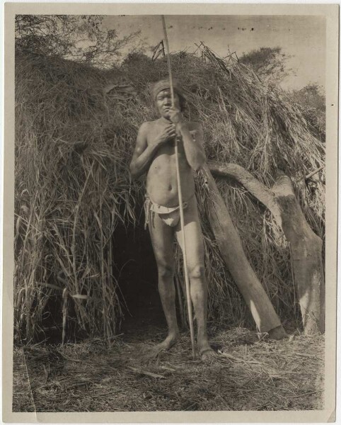 Mataco Indian in front of his hut