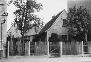 Anwesen : Blick auf ein umzäuntes Grundstück mit Haus und Scheune