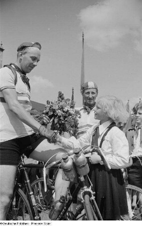 Radrennfahrer während des Überreichens eines Blumenstraußes