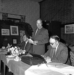 Kreisjägerschaft Stormarn e.V.: Rohlfshagen/Kupfermühle: Gastwirtschaft "Kupfermühle": Saal: Mitgliederversammlung: Podium mit Gremienmitgliedern: Rede des Kreisjägerschaftsvorsitzenden Hans Bünning