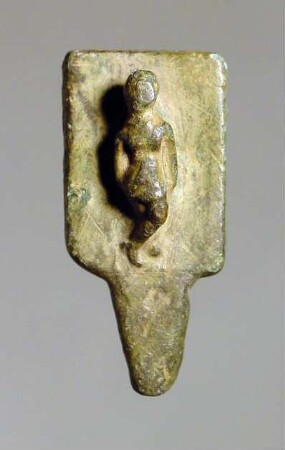 Zierplättchen mit einer kleinen Figur im Hochrelief